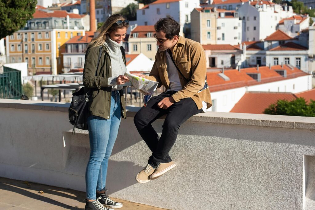 Two tourists using a map while sightseeing in a picturesque city with colorful buildings.